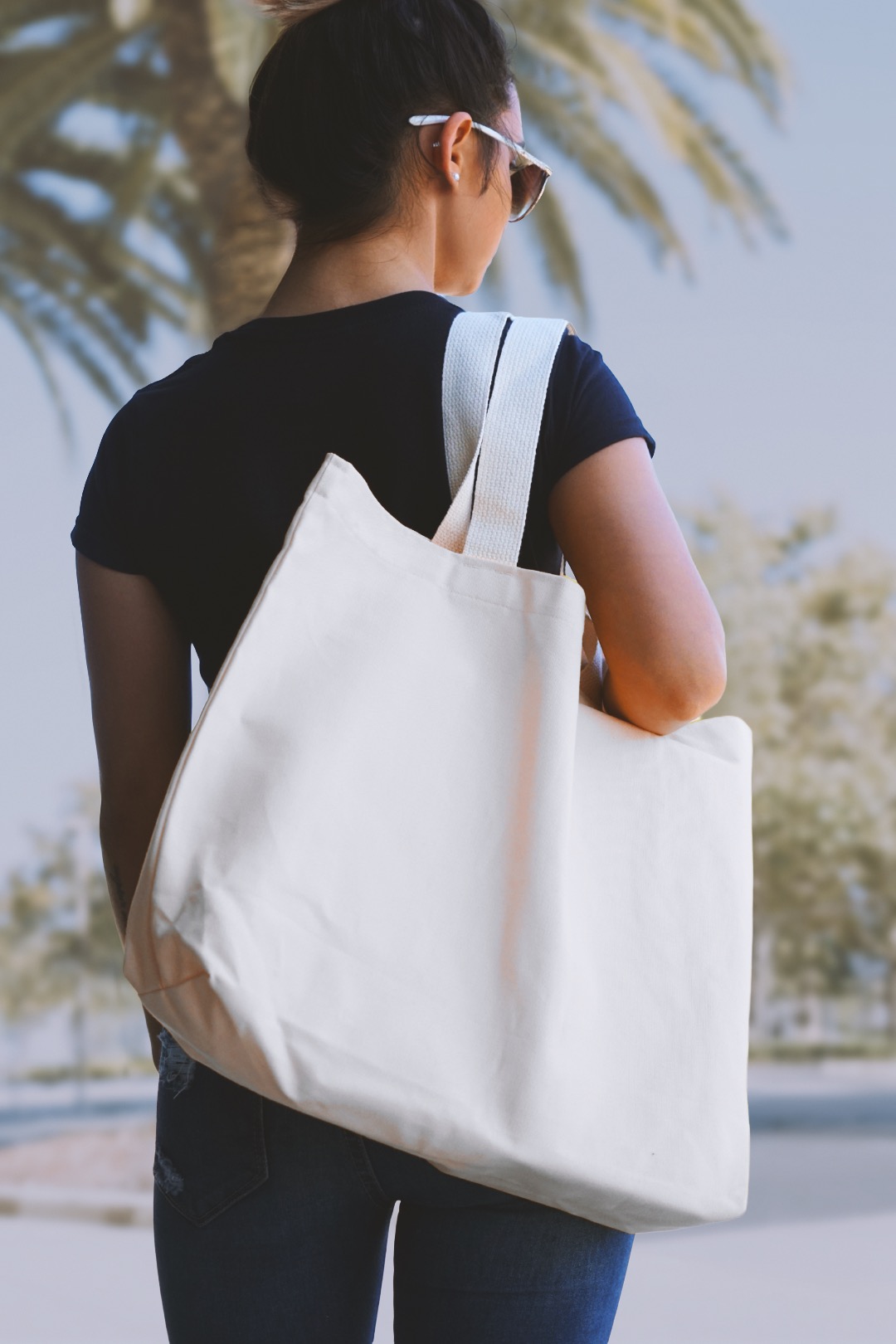 Woman carrying a natural canvas tote bag over her shoulder