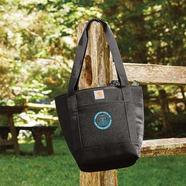 Black Carhartt tote bag with union logo, hanging on a fence post